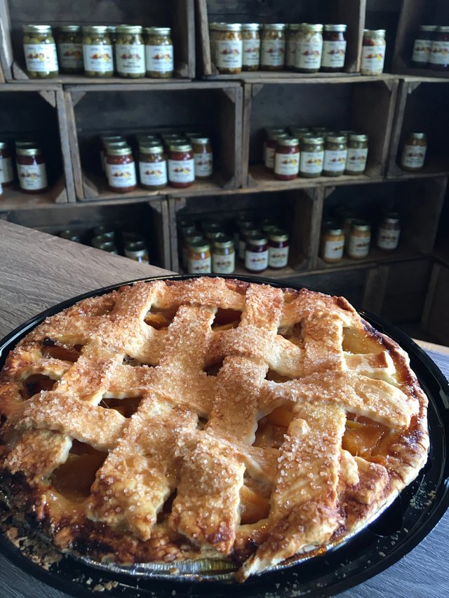 A golden lattice-topped fruit pie displayed inside Anita’s Pie Shop.